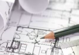 A pencil and ruler rest on architectural blueprints.