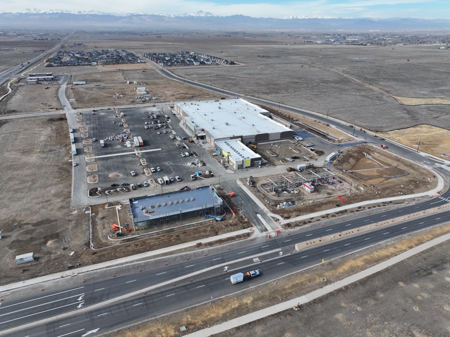 Aerial view of a large commercial construction site with parking and roadways 