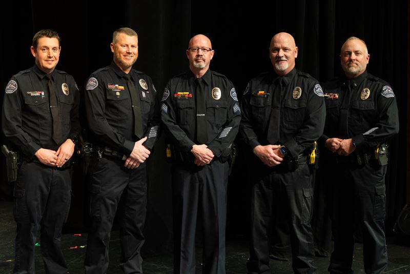 Five School Resource Officers in uniform, posed on stage.